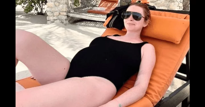 Lindsay Lohan flaunts baby bump in stylish black swimsuit, as she lounges by pool